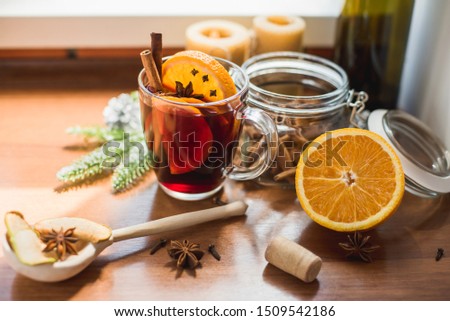 A mug of hot homemade mulled wine with spices and orange, decorated in the spirit of Christmas.