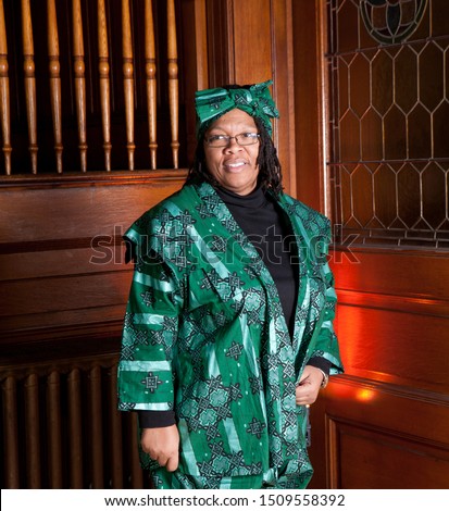 African American woman in a church with traditional green dress and head bandana