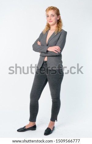 Full body shot of beautiful blonde businesswoman with arms crossed