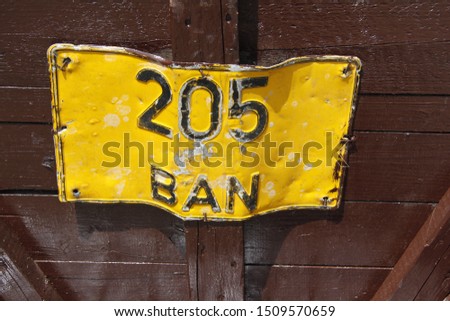 bent and damaged sign 205 ban in vivid yellow in rural romania