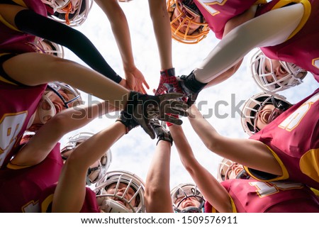 Picture of female rugby players stacking their hands together