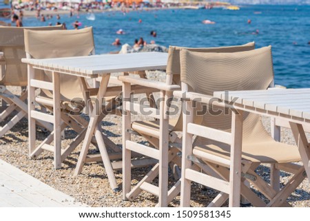 Empty table and chairs in restaurant on the beach, Kos island, Greece. Beach cafe near sea, outdoors. Travel and vacation concept
