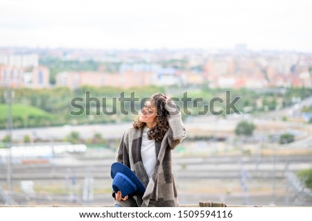 Beautiful woman posing at camera watching the city in the background
