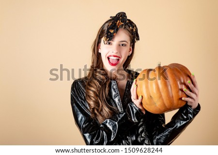 Beauty witch halloween with funny emotion. Young Beautiful Woman with pumpkin. Beauty Woman face Portrait for halloween banner. Yellow background isolated
