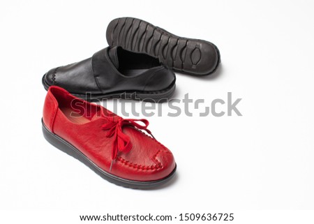 Set of autumn shoes black ankle boots and one red on a white background. Top view. Copy space text