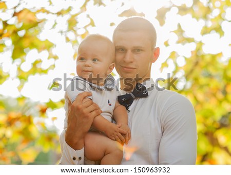 Happy young man holding a smiling 7-9 months old baby