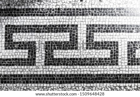 Ancient stone mosaic tiling with black and white classic geometric pattern, background photo texture