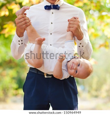 Happy young man holding a smiling 7-9 months old baby