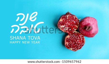 Picture of a pomegranate fruit symbol of a Jewish holiday called Rosh Hashanah and with Hebrew text greeting the New Year and English written shana tova that is Happy Holidays