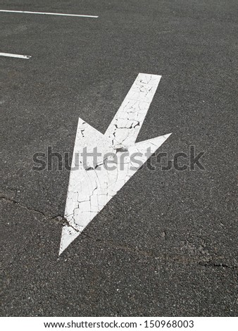 arrow sign on the parking lot pavement