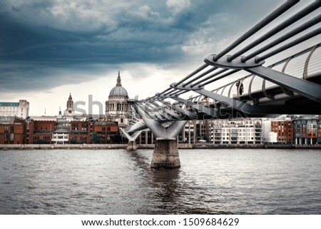 Saint Paul Cathedral and the Millennium Bridge in London on a typical cloudy day