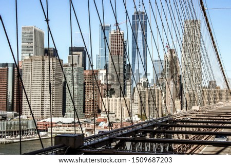 Ccinematic look of the skyline of Lower Manhattan, New york. Taken from the Brooklyn Bridge with the steel cables crossing the image, United States of america.