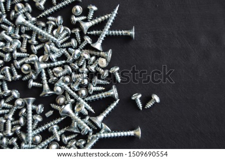Different size screws and black background.