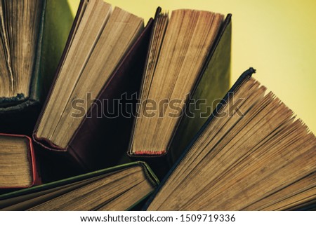 Open old books on a green background table. Top view.