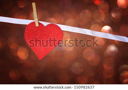 red glitter heart hang over brown bokeh background