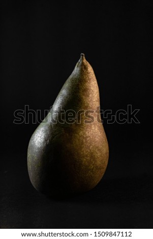 Fresh, sweet and juicy isolated pear on the dark, black background.