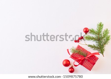 Flat lay christmas frame with evergreen tree branch, balls and berries on a white background