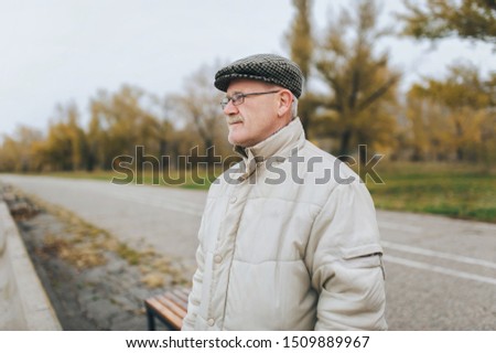 An old man in a jacket, cap and glasses looks into the distance. The concept of retirement age and poor vision. Hyperopia, myopia. The gray-haired man. Royalty-Free Stock Photo #1509889967