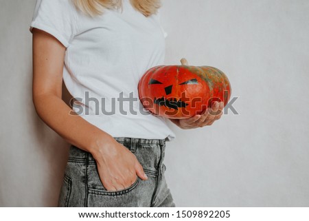 Halloween pumpkin. Woman holding a scary face pumpkin. Happy Halloween party holiday. Celebrate annual in October 31. Autumn season. Fall color, orange and yellow. Trick or treat. Space for text