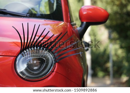 Car Lamp Detail, Black Eyelashes Decoration. Red Car on The Street in Stuttgart City of Germany. Royalty-Free Stock Photo #1509892886