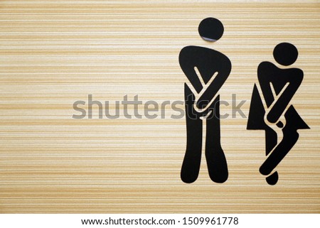 Comic toilet sign symbols with woman and men on wooden background