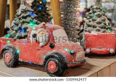Toy Santa Claus ride a red car in snow, Christmas card, New Year decoration, go to winter time
