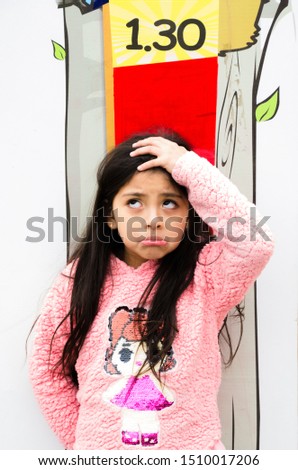 Little girl is measuring growth on the background of the wall. Growth concept