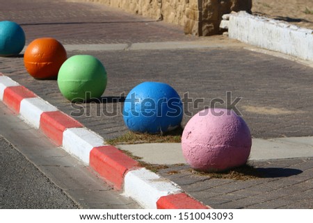 multi-colored concrete balls lie on the sidewalk in the city