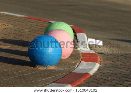 multi-colored concrete balls lie on the sidewalk in the city