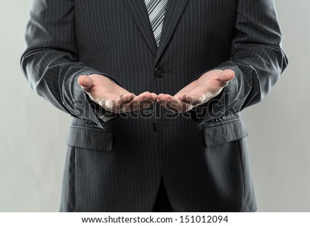 Businessman with empty hands sharing something. Luxury dressed man holding something in his open hands for promotion.  