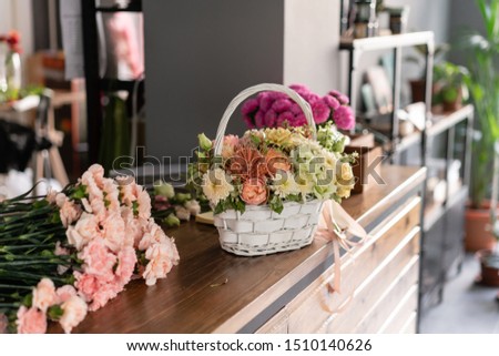 Beautiful flower composition a bouquet in a wicker basket. Floristry concept. Spring colors
