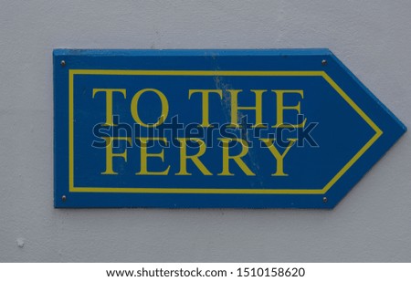 "To the Ferry" Sign Attached to a White Wall in the Seaside Town of Marazion on the South Coast of Cornwall, England, UK