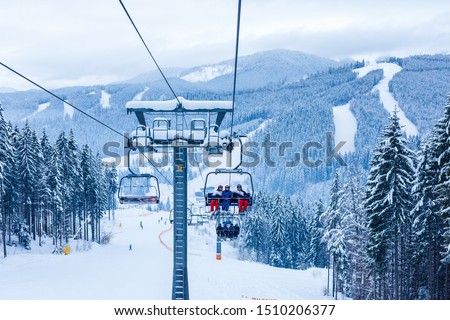 Skiers on chairlift at ski resort Royalty-Free Stock Photo #1510206377