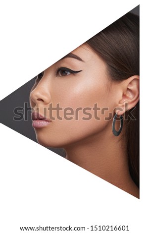 Closeup side view shot of woman with straight dark hair wearing steely metallic congo earring made in the shape of wide flat ring. 