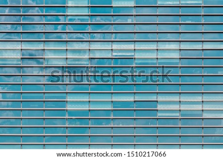 Fragment of window wall of a modern office building. Business or finance center. Turquoise and blue texture for background