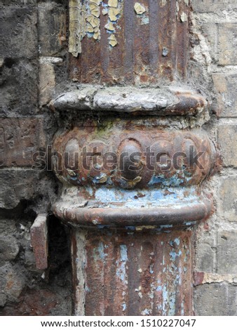 Rusty old traditional pipe with a brick wall background in Toulouse, southern France