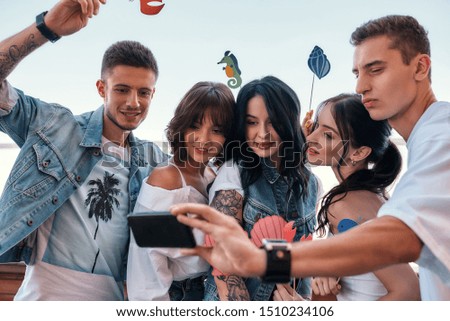 Happy moments. Group of happy friends making a selfie while having party on rooftop