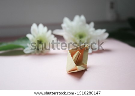 Flowers and paper boat on pink background