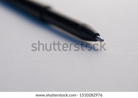 Black Ball point pen on a white paper macro shot diagonal selective focus