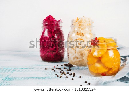 Fermented vegetables in jars. Sauerkraut, pickled beets and pickled squash on a light wooden background. Traditional Russian pickles. Copy space