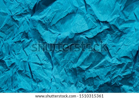 Blue crumpled paper background with folds