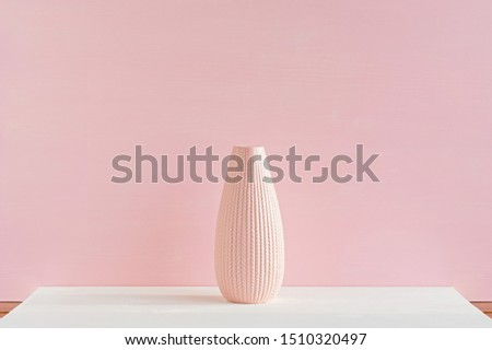 Ceramic vase on a pink background. Close-up. The concept of minimalism.