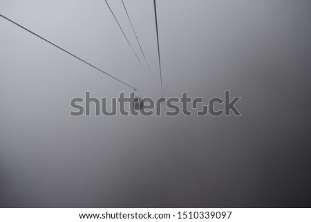 cable caars running in a misty mountain