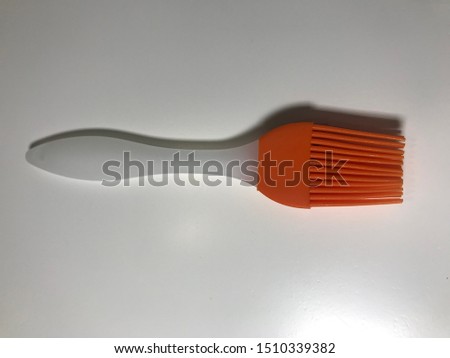 Buy orange white cook chef brush food composition made on lubrication brush backdrop.