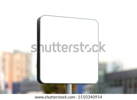 Blank white road sign on blurry urban background