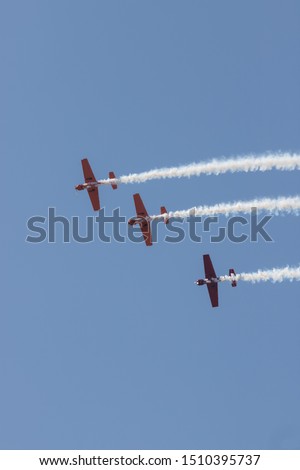 Three colorful jets flying in the blue sky and performing a show leaving smoke marks - flying in straight line