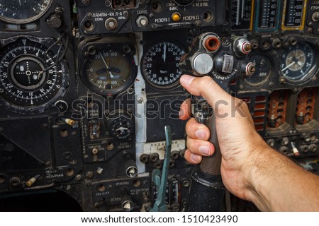 Pilot's hand on the military aircraft control knob. In the cockpit of an old, Soviet military jet. Close-up. Text translation from Russian "pitching nose up" Royalty-Free Stock Photo #1510423490