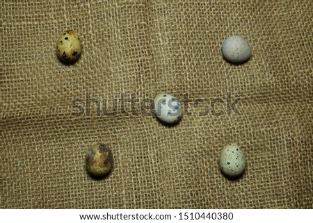 A picture of 5 scattered quail eggs on sackcloth before making "sambal" or Malaysia spicy sauce.