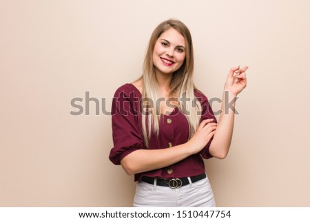 Young russian woman pointing to the side with finger
