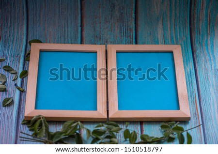 Picture frame on blue wooden background.